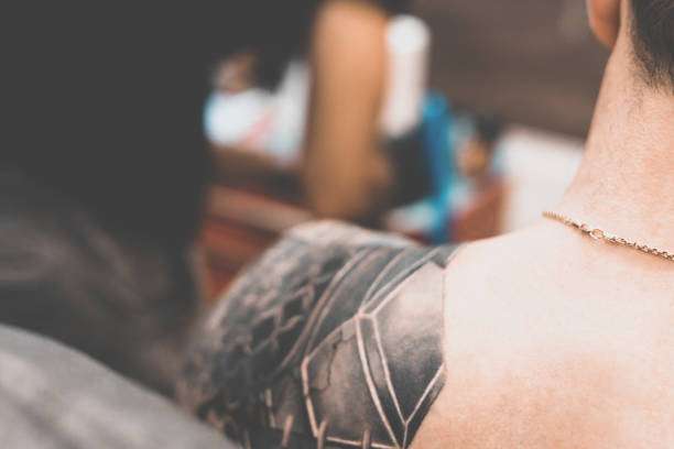 Geometric black tattoo on a shoulder, showcasing artistic tattoo ink application.